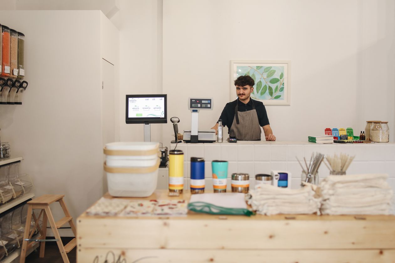Commerçant derrière le comptoir de sa boutique de produits en vrac