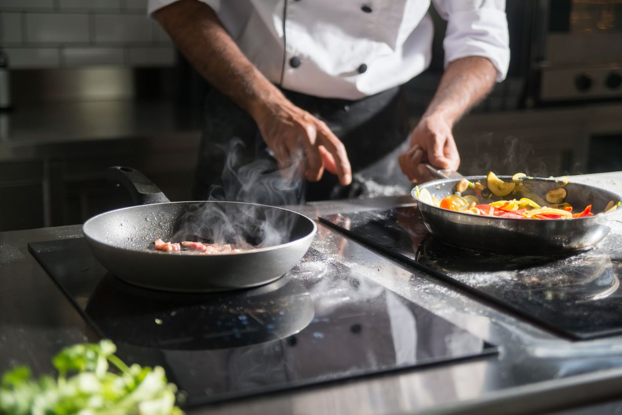 Cuisinier préparant des légumes dans une cuisine professionnelle
